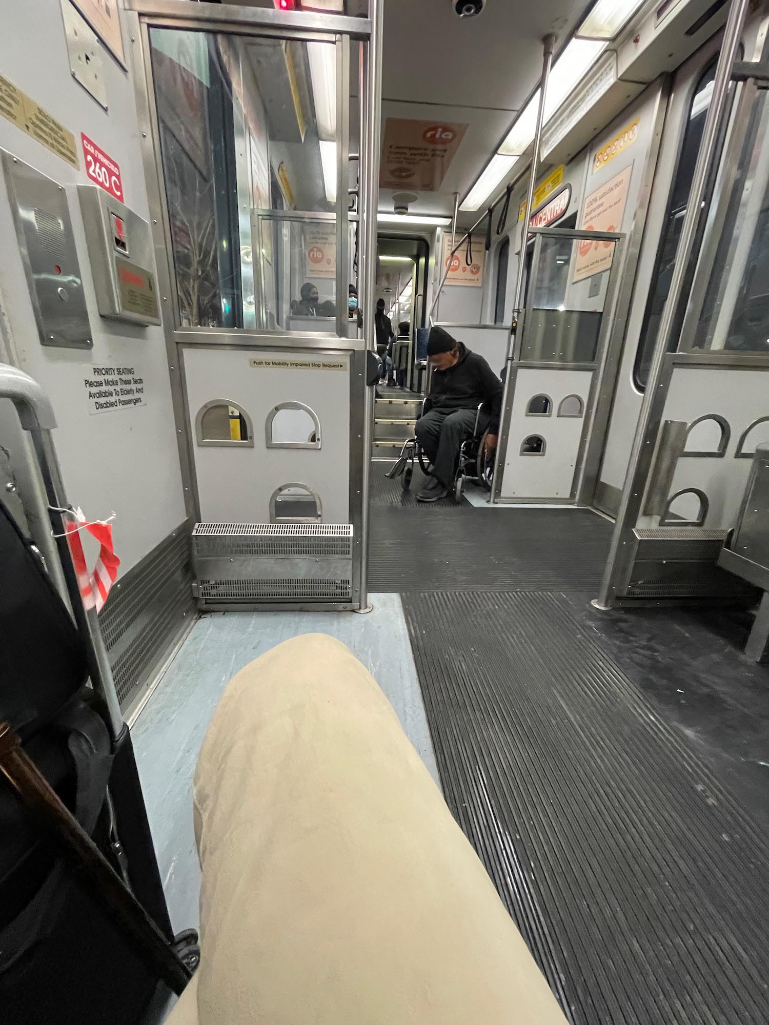 a person sitting in a wheelchair in a subway car