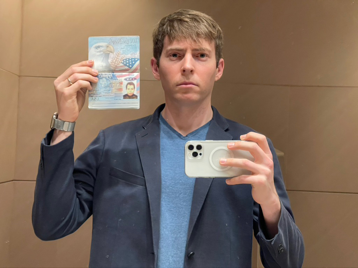 a man holding a camera and a passport