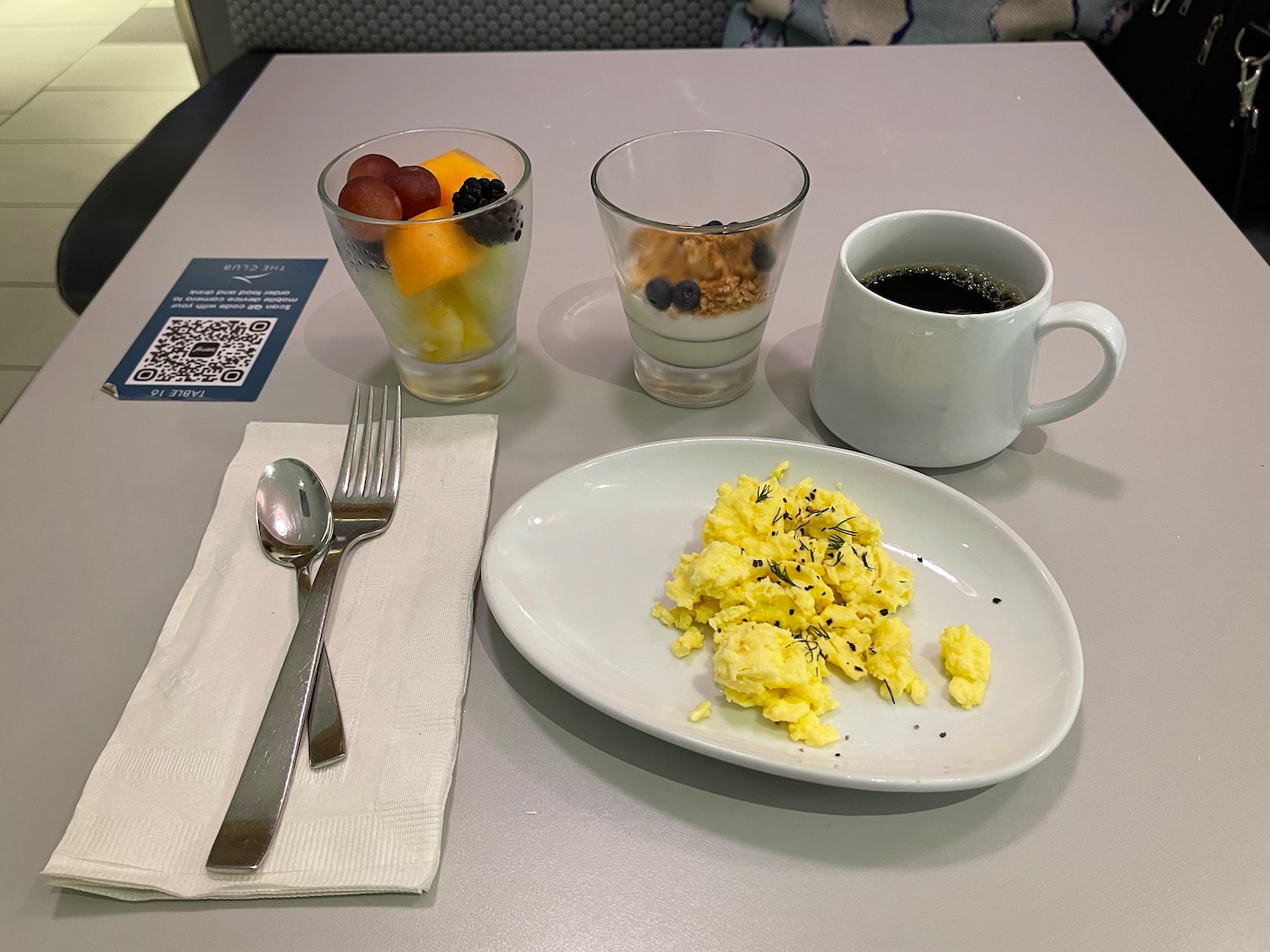 a plate of scrambled eggs and a cup of coffee