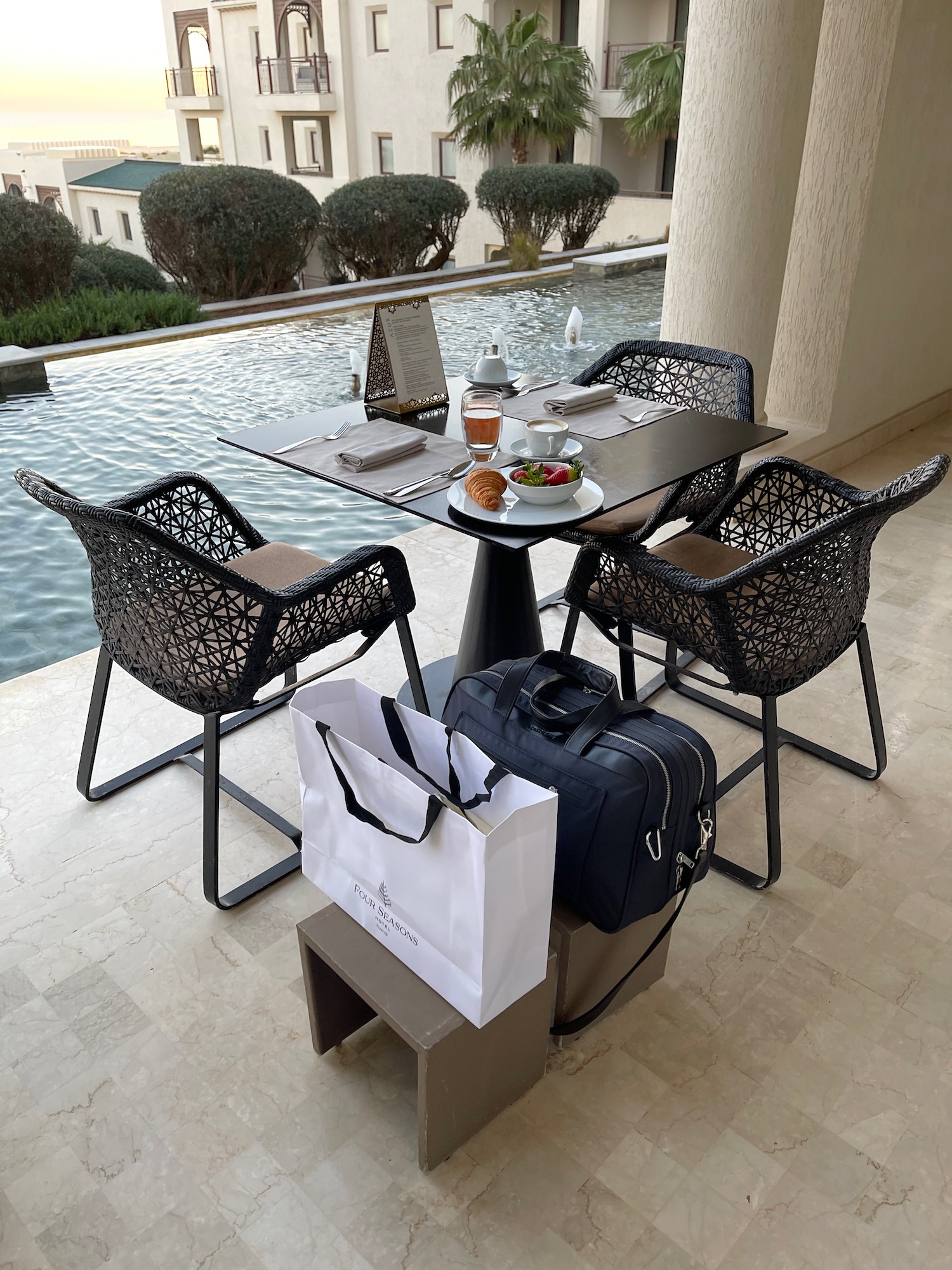 a table and chairs with food and luggage on a patio