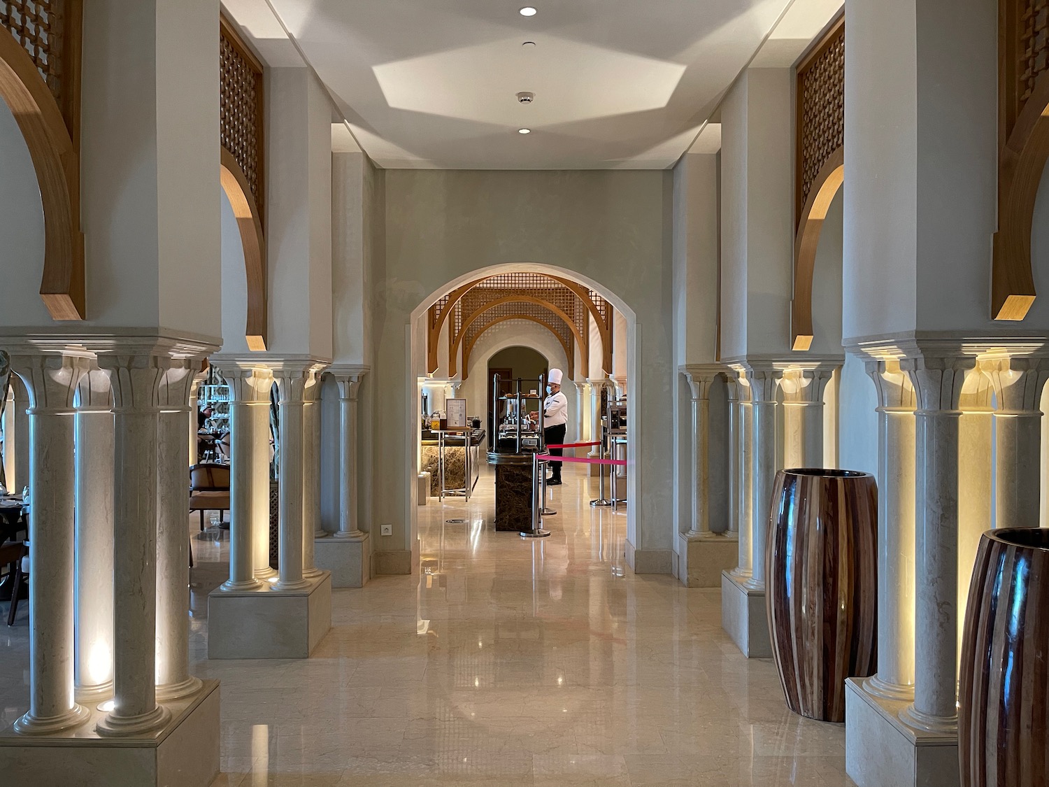 a hallway with columns and a man standing in the background