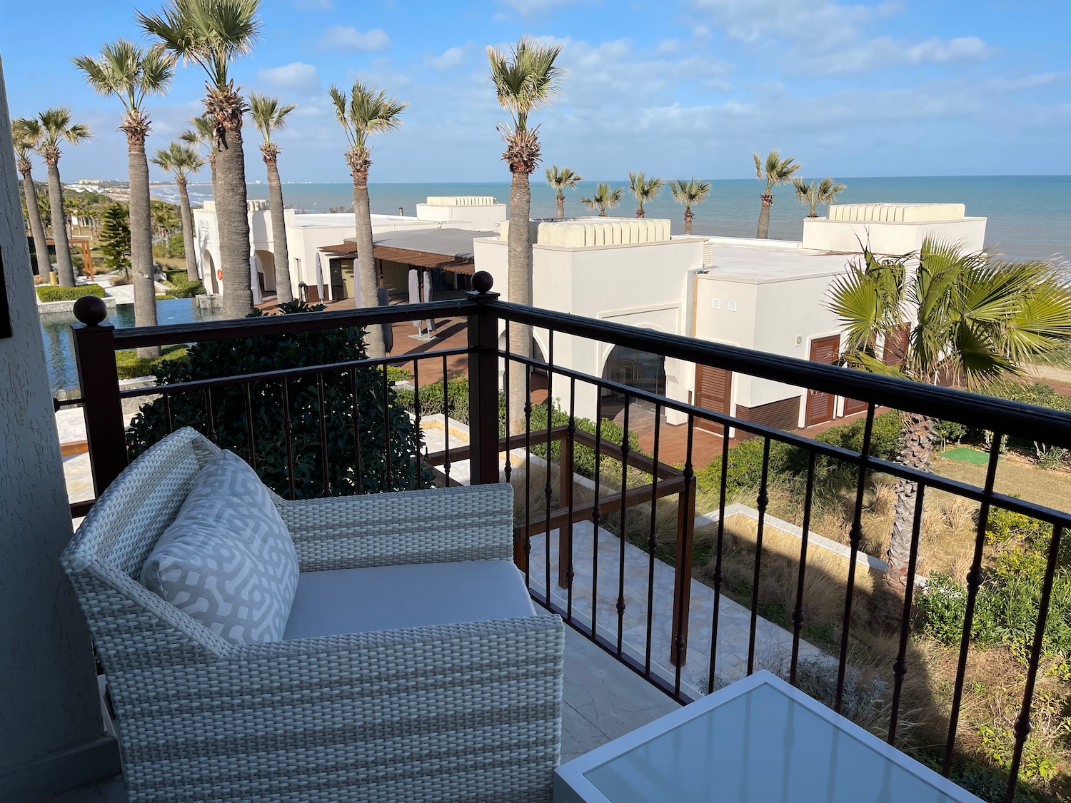 a balcony with a view of the ocean and palm trees