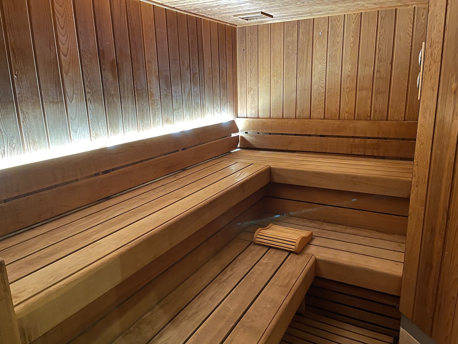 a wooden sauna with a light shining on the wall