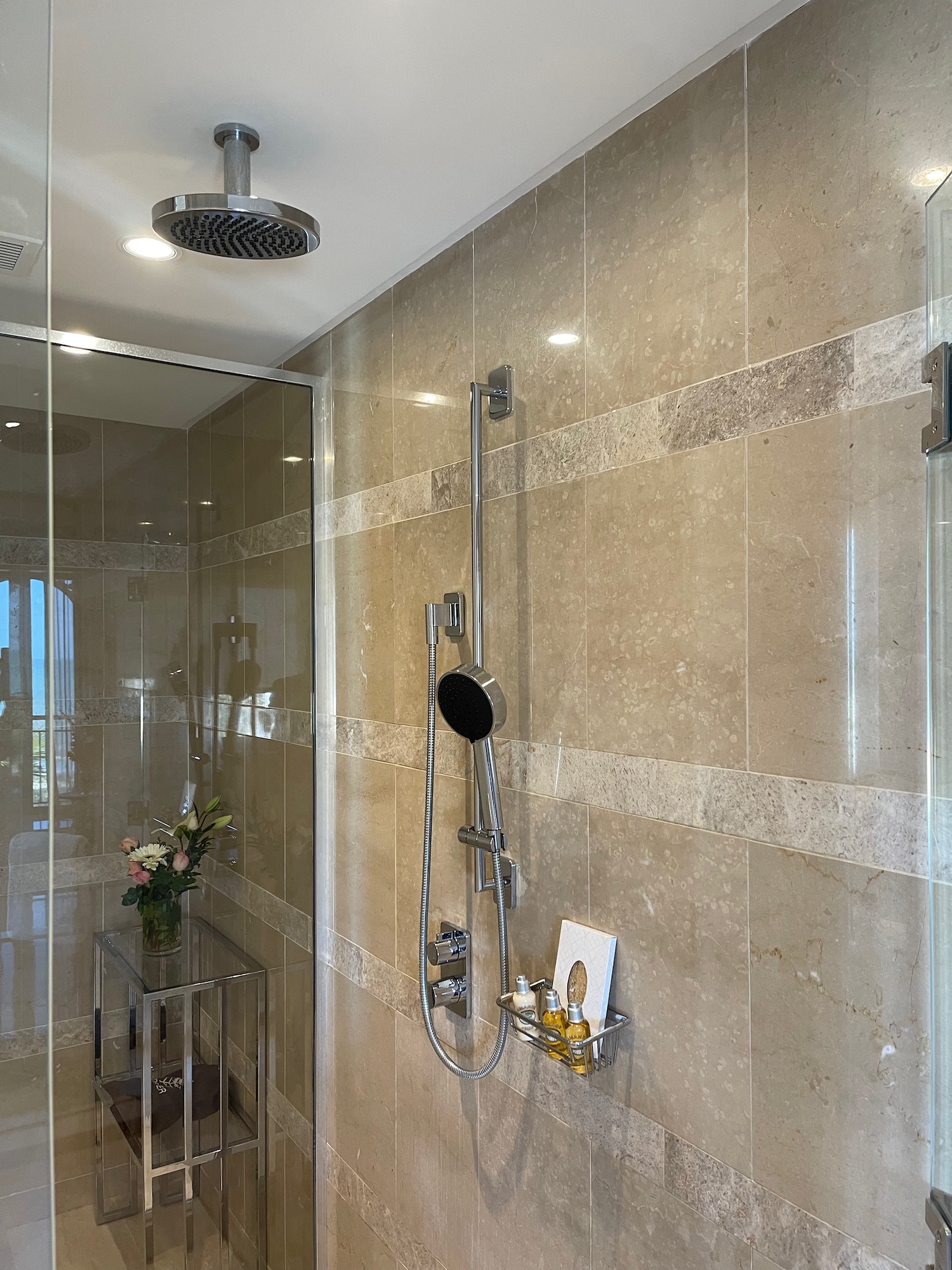 a shower with a glass shower and a glass shelf