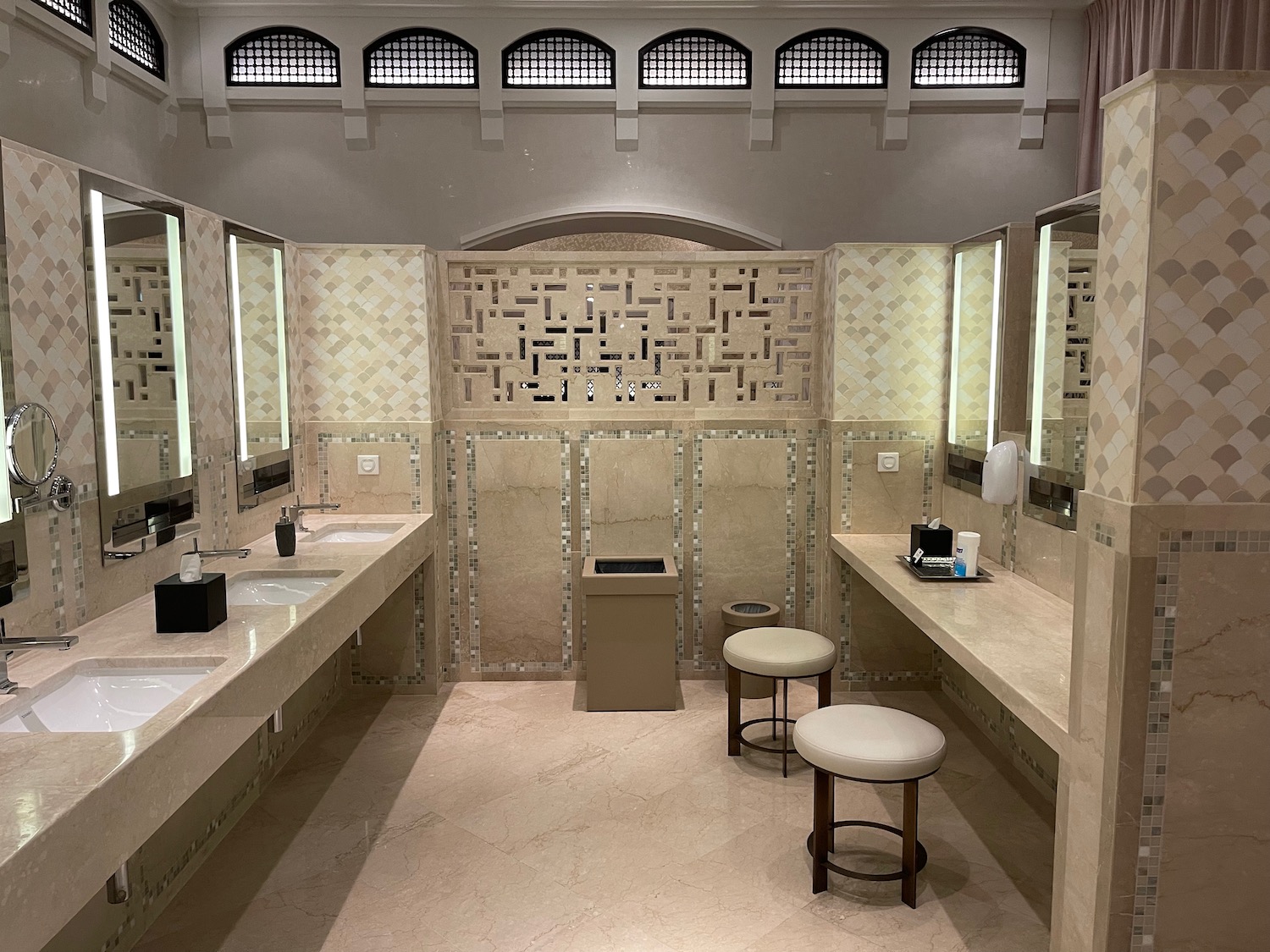 a bathroom with sinks and stools