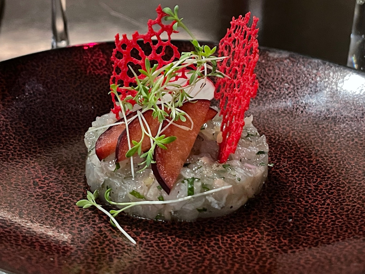 a plate of food with a red mesh decoration