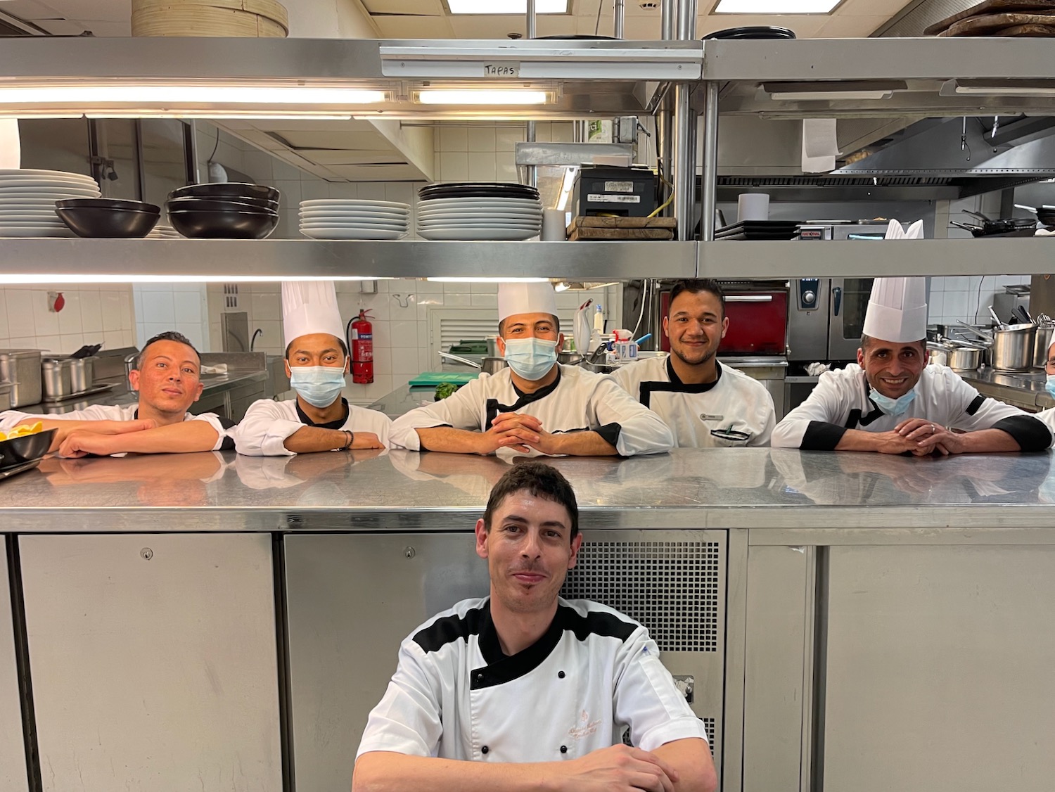 a group of men in uniforms in a kitchen