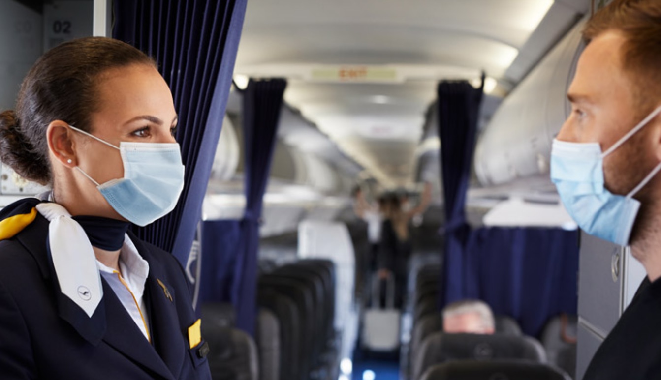 a woman wearing a face mask on an airplane