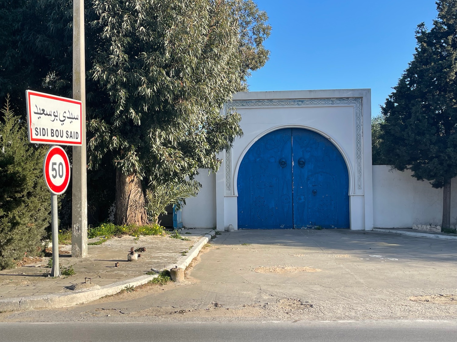 a blue door with a white wall and a sign