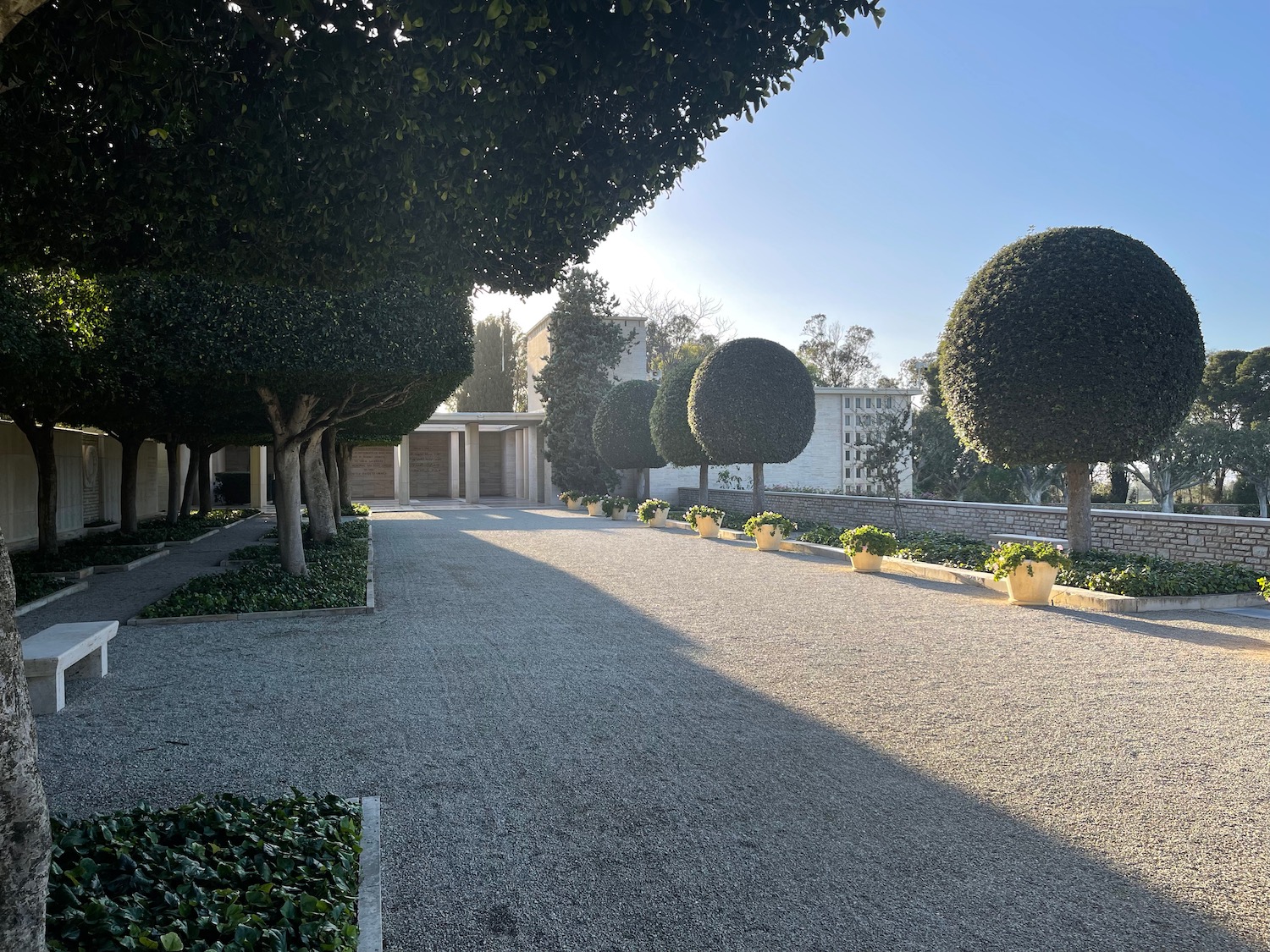 a gravel road with trees and a building