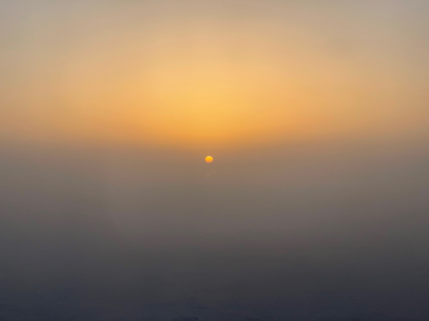 a sun setting over a foggy area