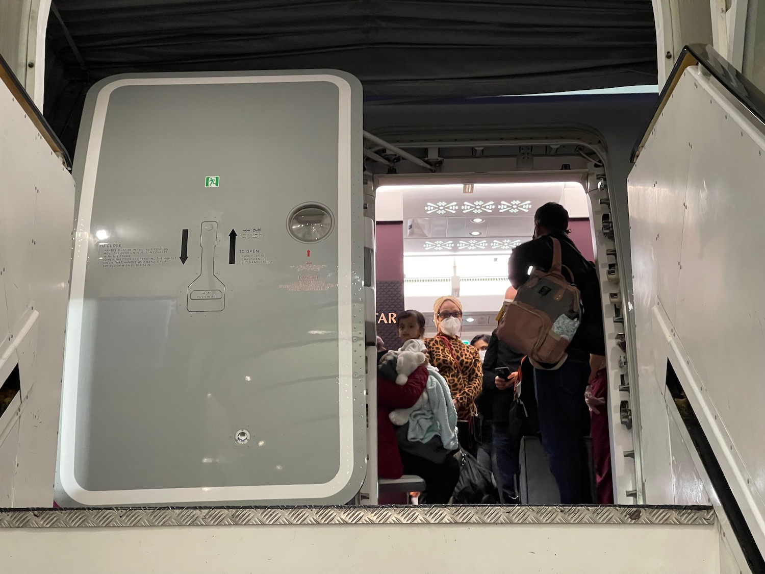 a group of people standing in a room with a door open