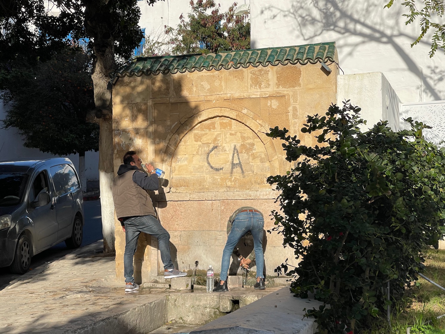 a man standing next to a stone wall