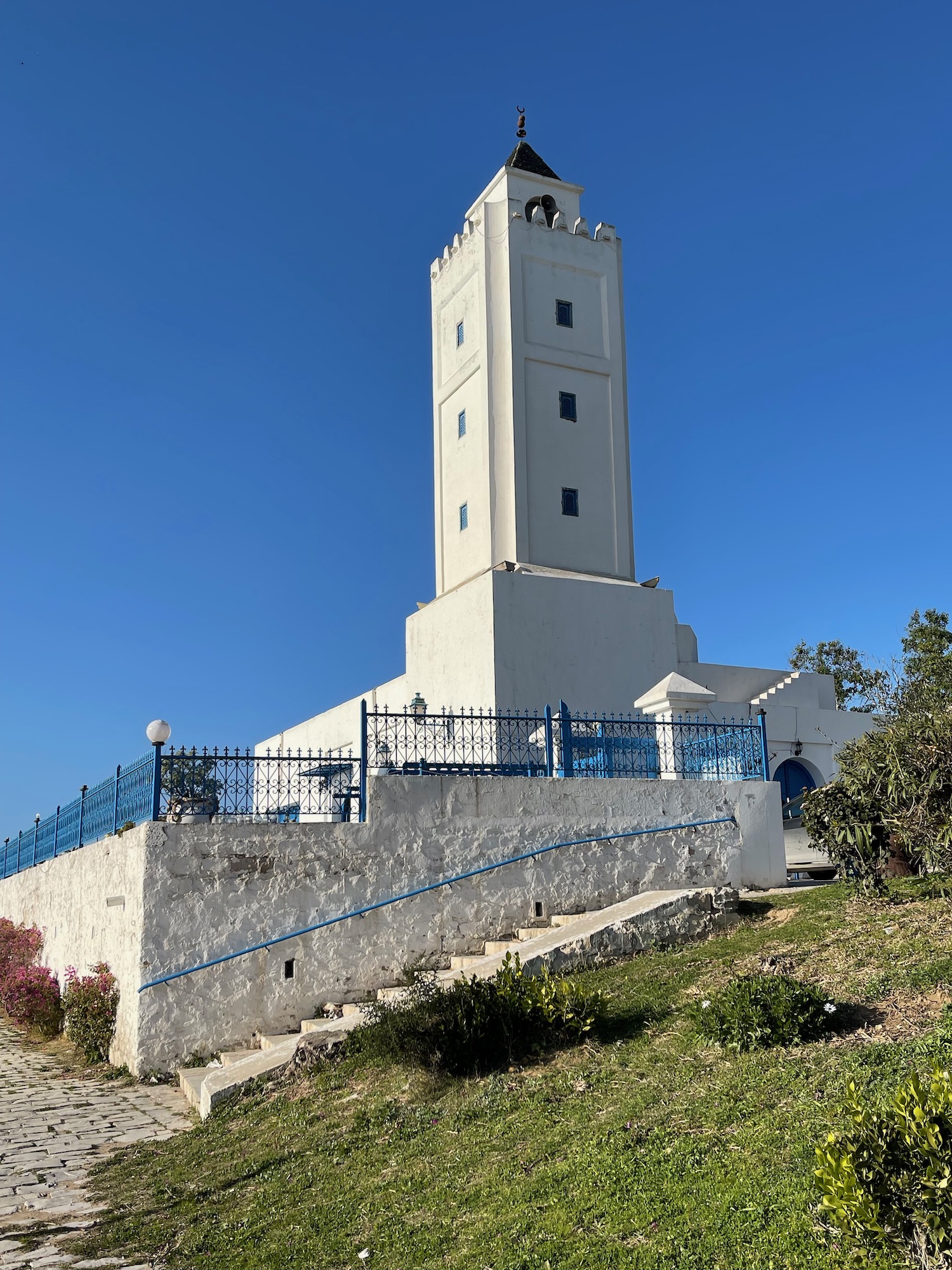 a white tower with a blue fence