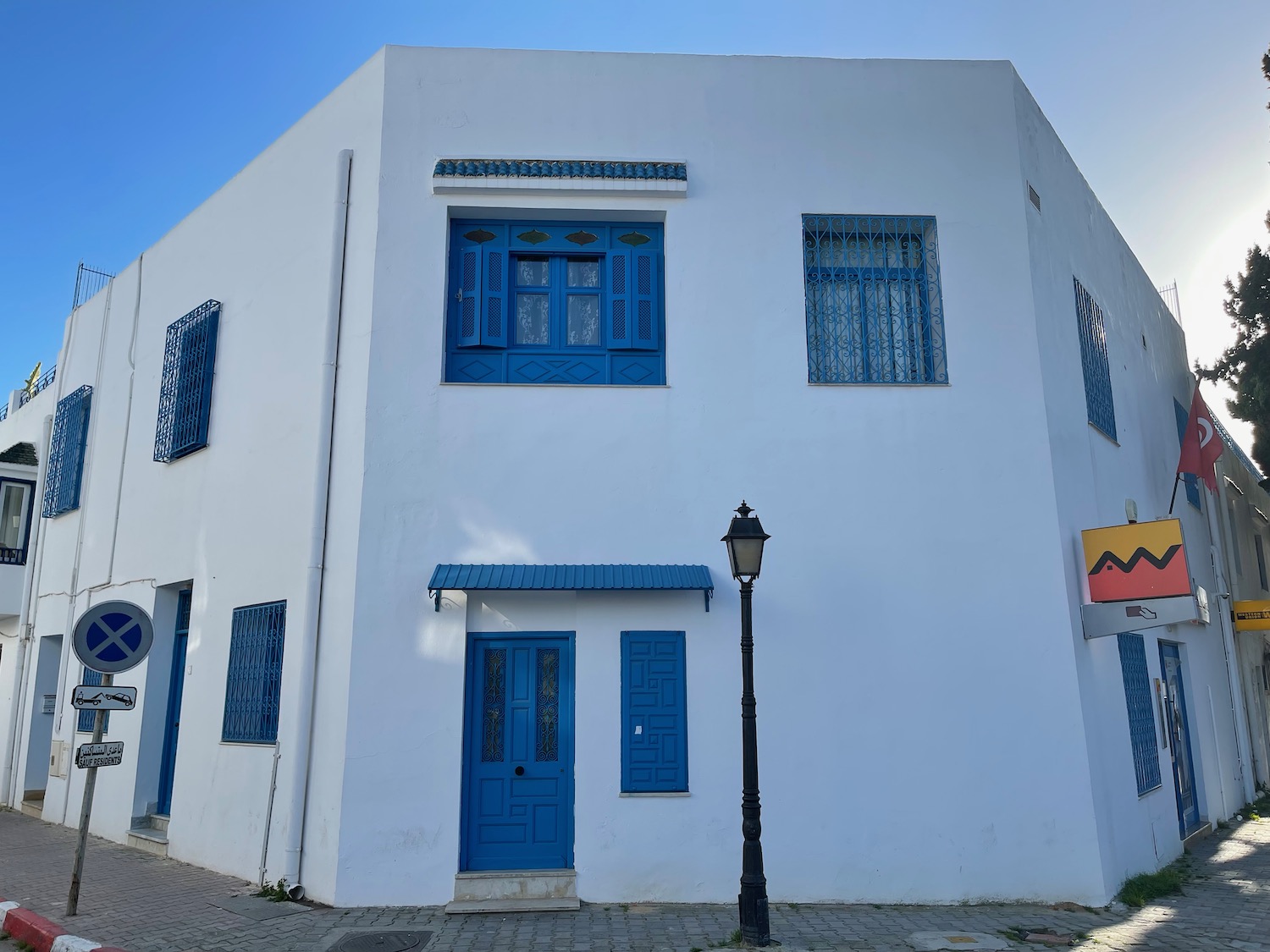 a white building with blue doors and a lamp post