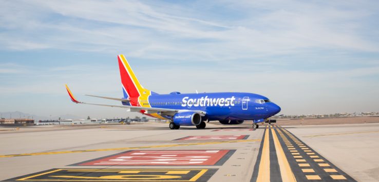 a blue airplane on a runway