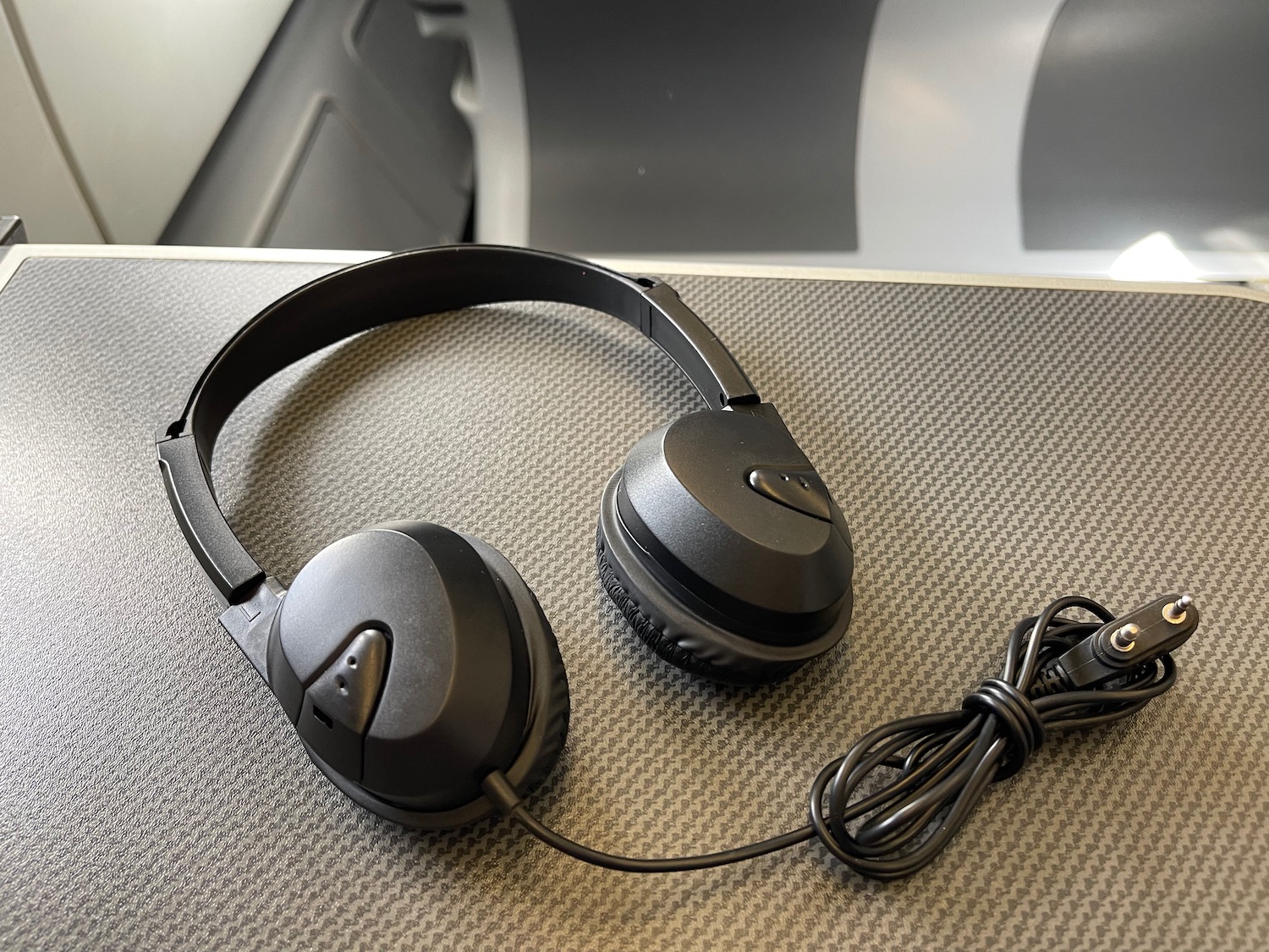 a pair of black headphones on a grey surface