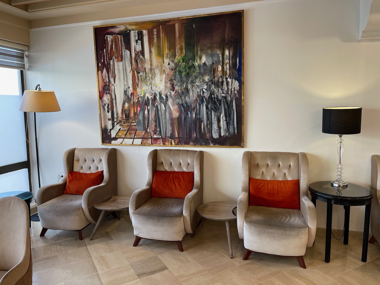 a group of chairs in a room with a painting on the wall