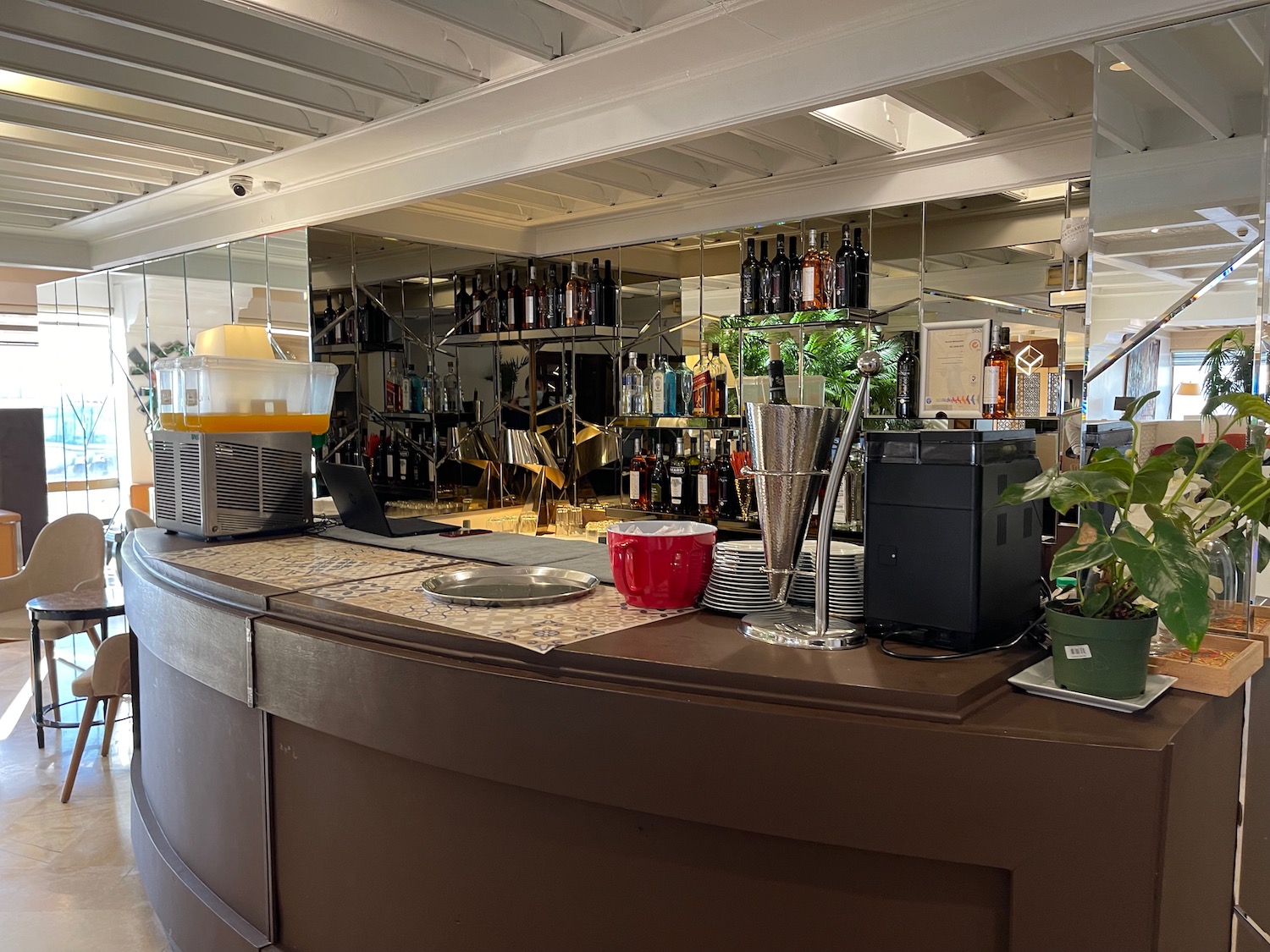 a bar with a mirror wall and shelves of alcohol