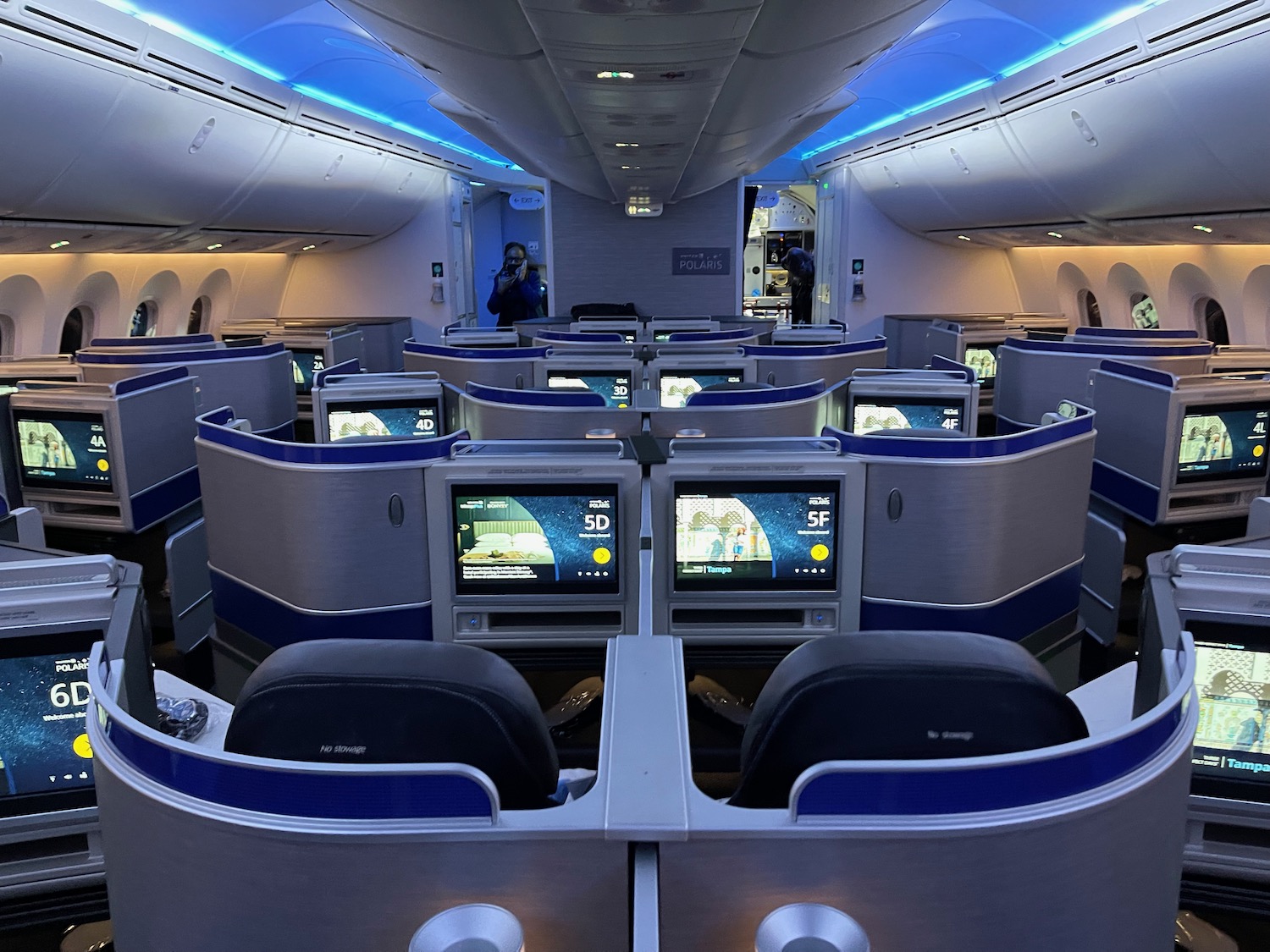 an airplane with rows of seats and monitors
