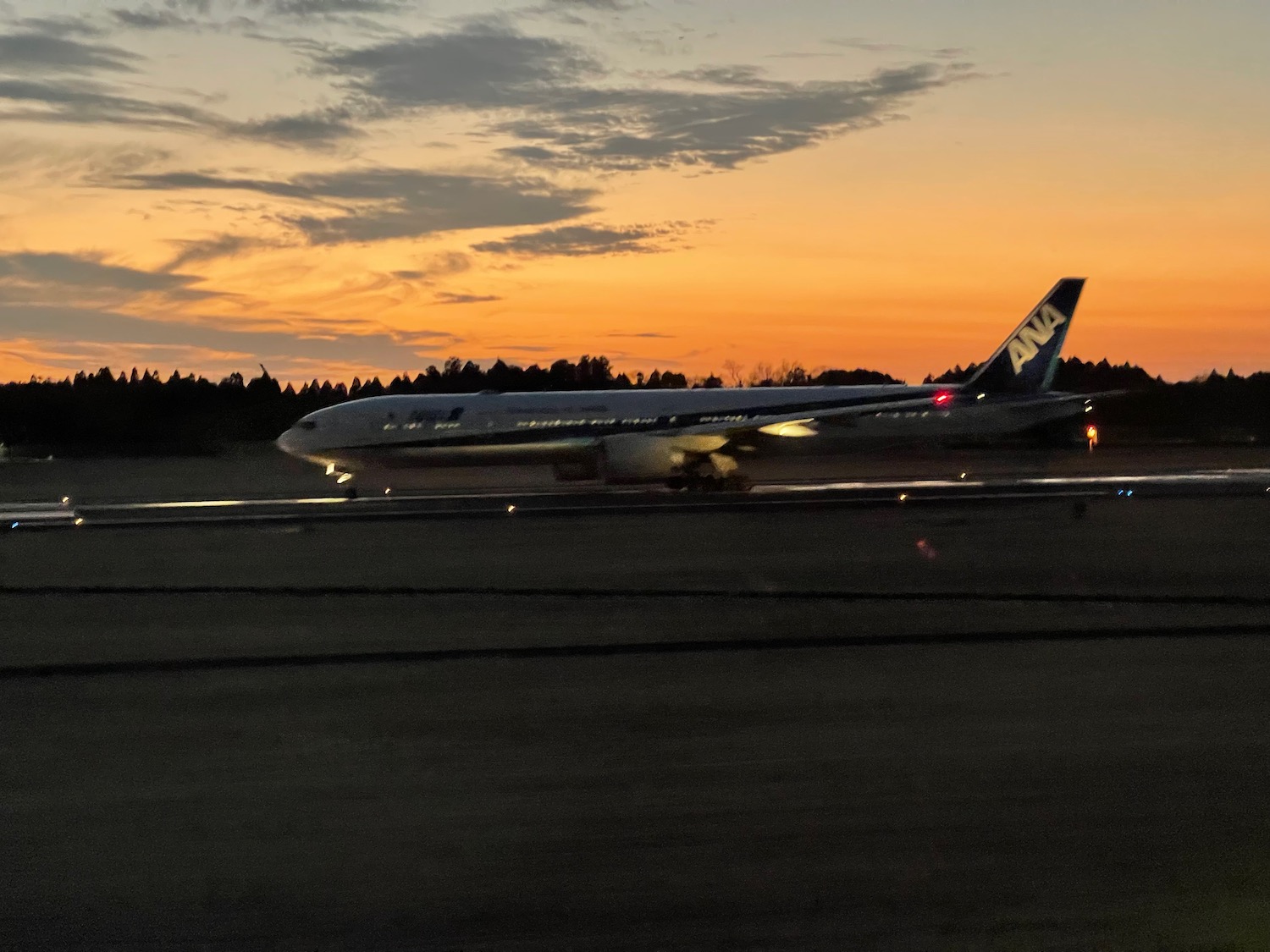 an airplane on the runway at sunset