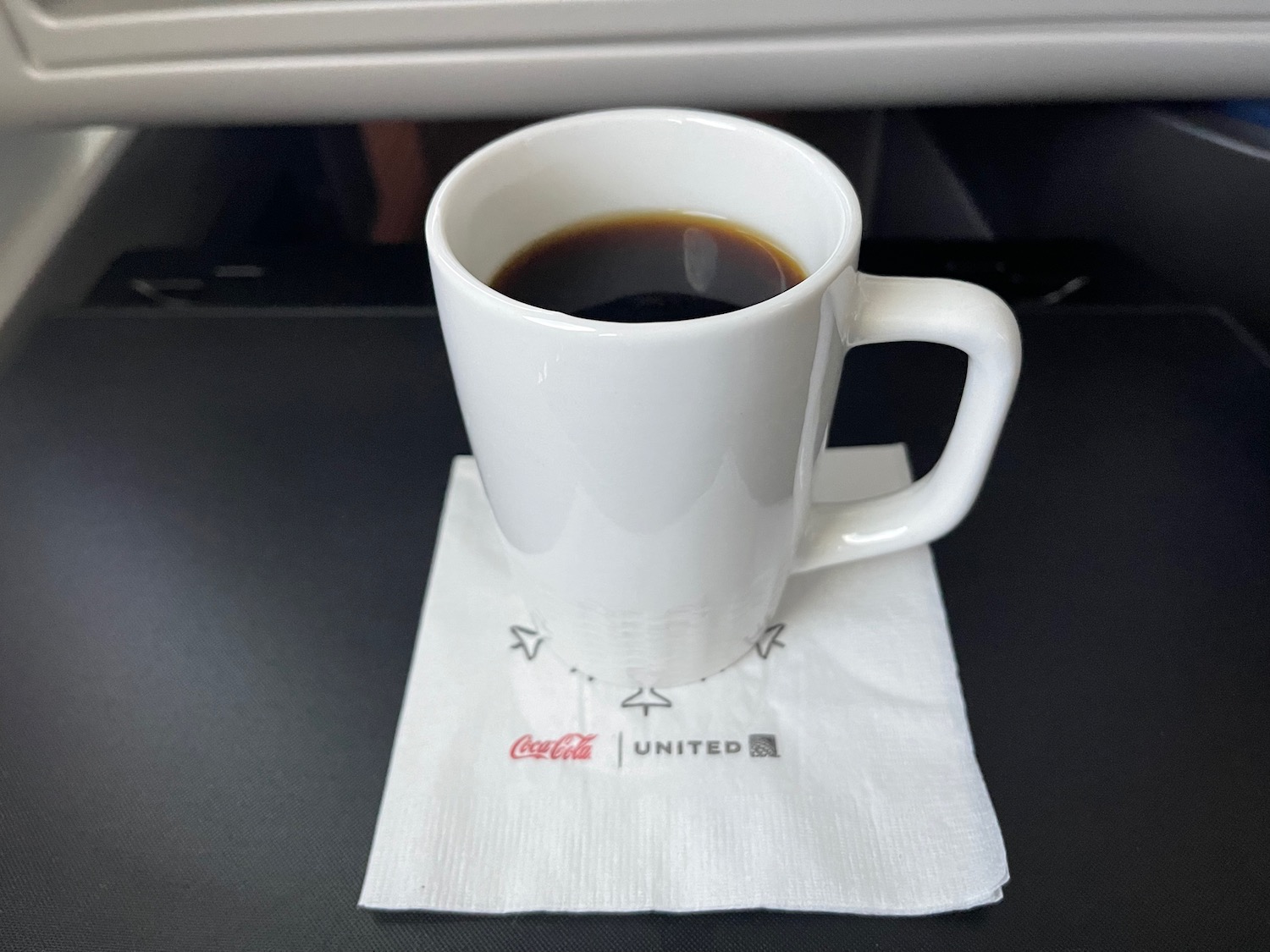 a white mug with a drink on a napkin