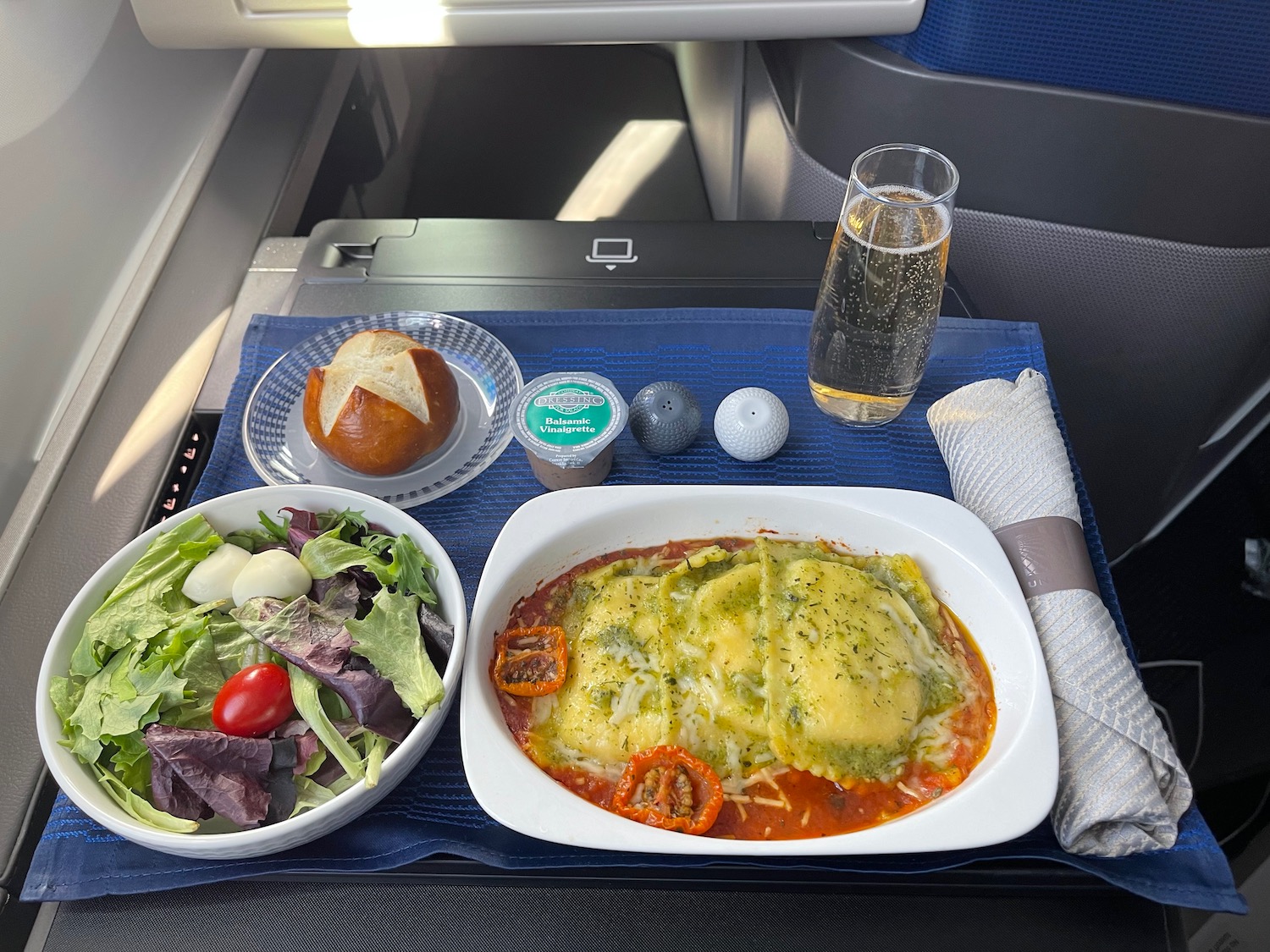 food on a tray with a salad and a glass of champagne