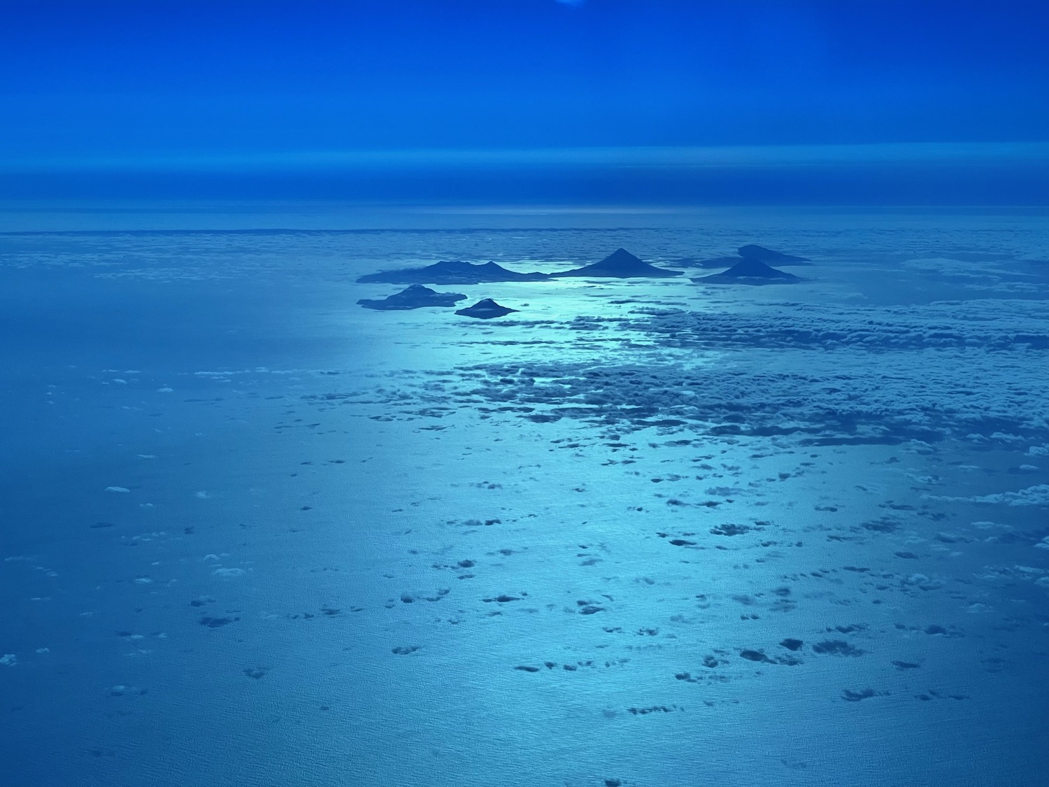 a blue sky with clouds and a group of islands