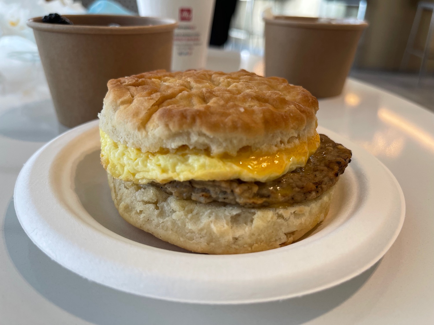 a biscuit with egg and sausage on a plate