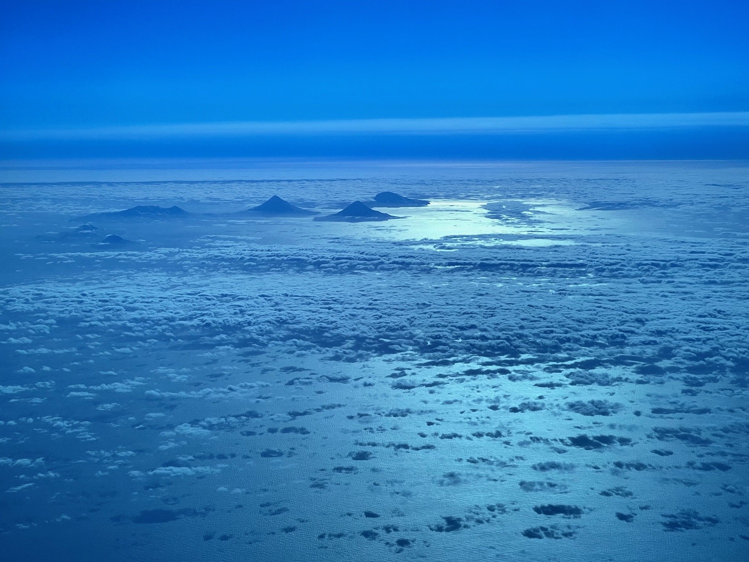 a blue sky with clouds and mountains