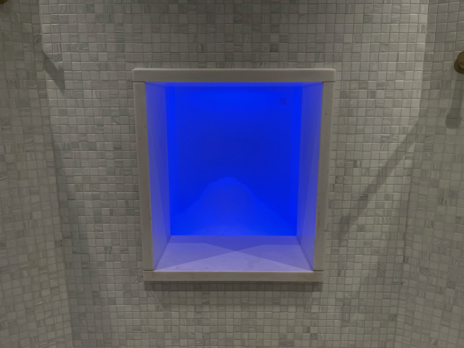 a blue light in a square niche