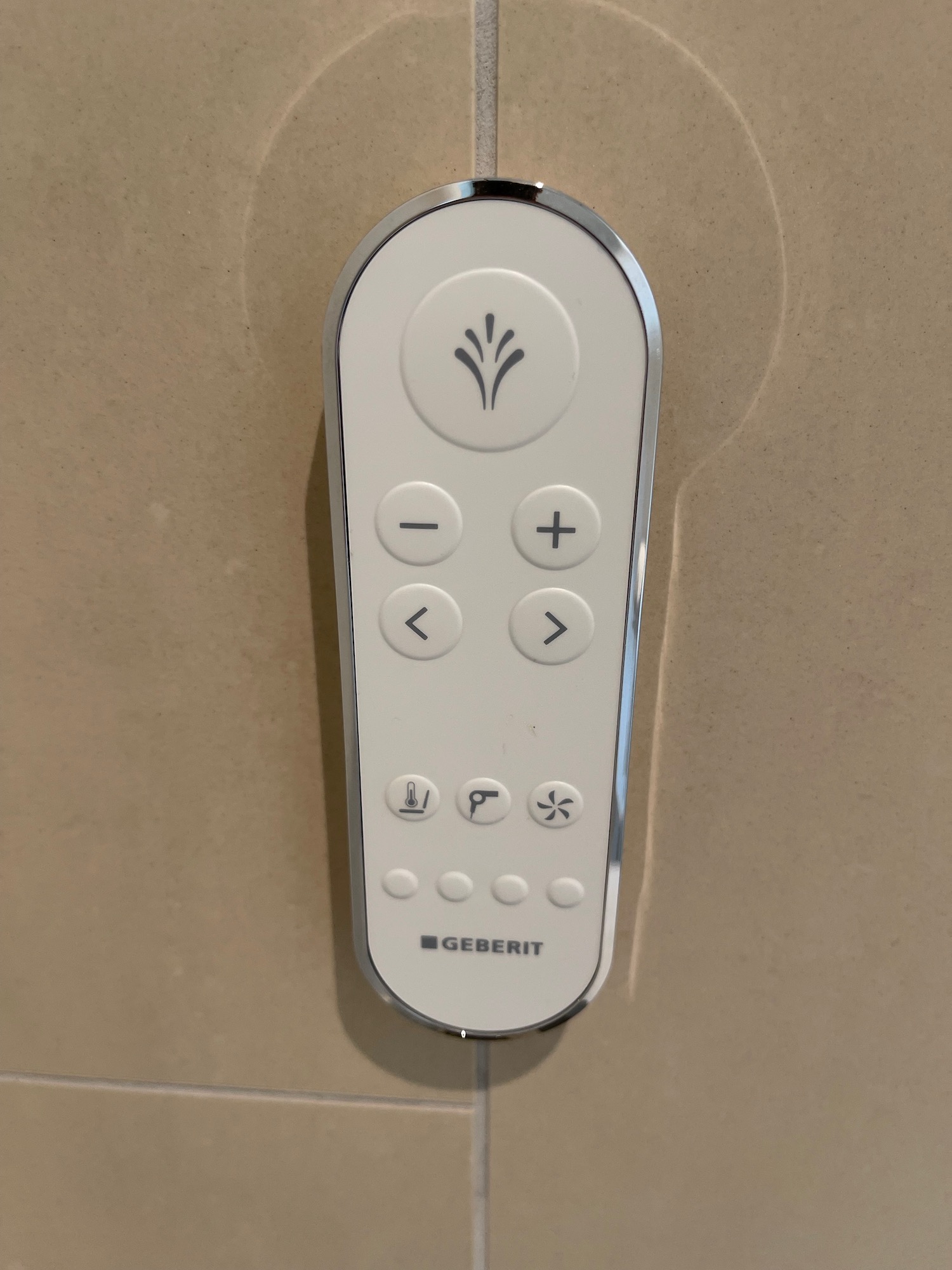 a white remote control on a tile wall