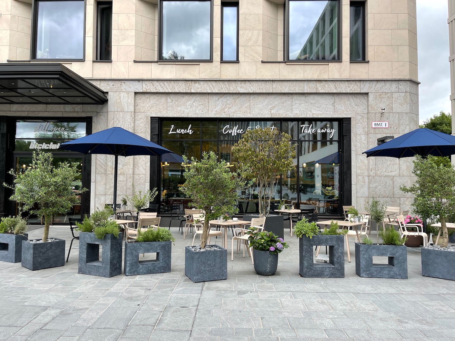 a building with tables and chairs and umbrellas