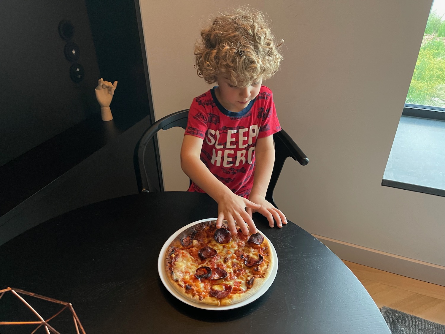 a child sitting at a table with a pizza