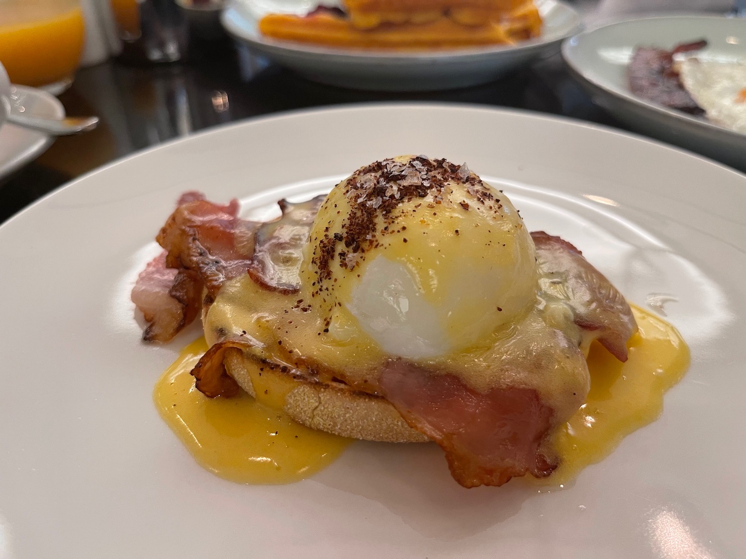 a plate of food with eggs benedict and bacon