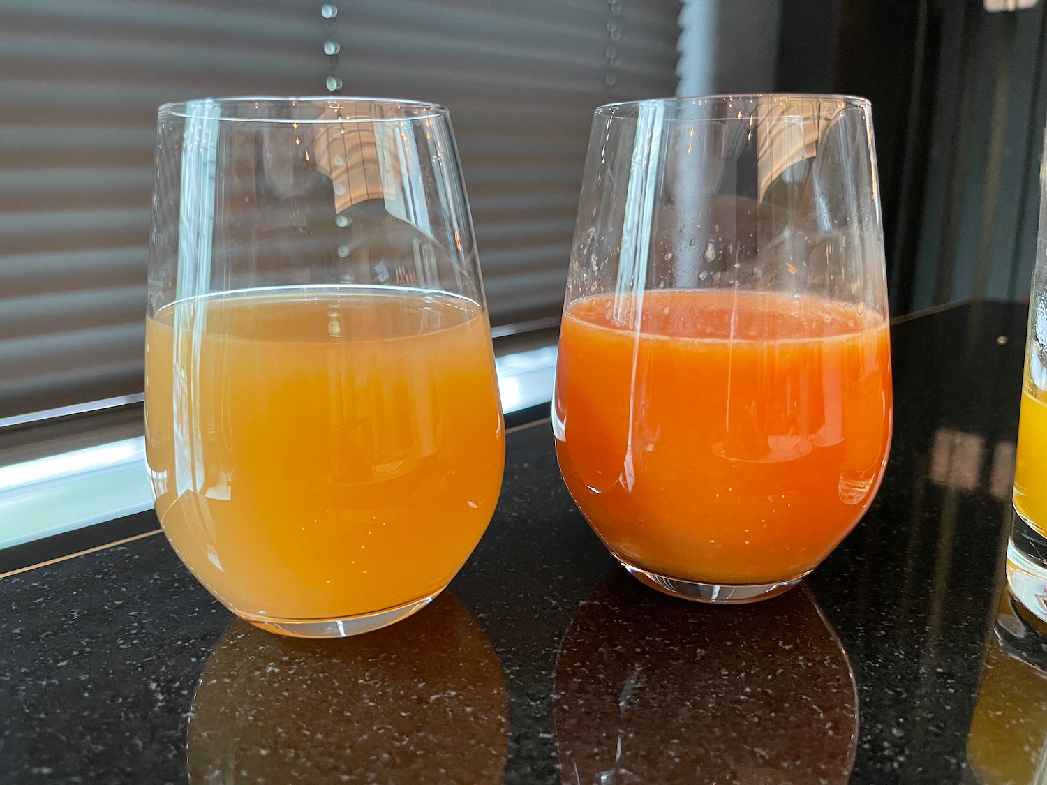 two glasses of orange juice on a counter
