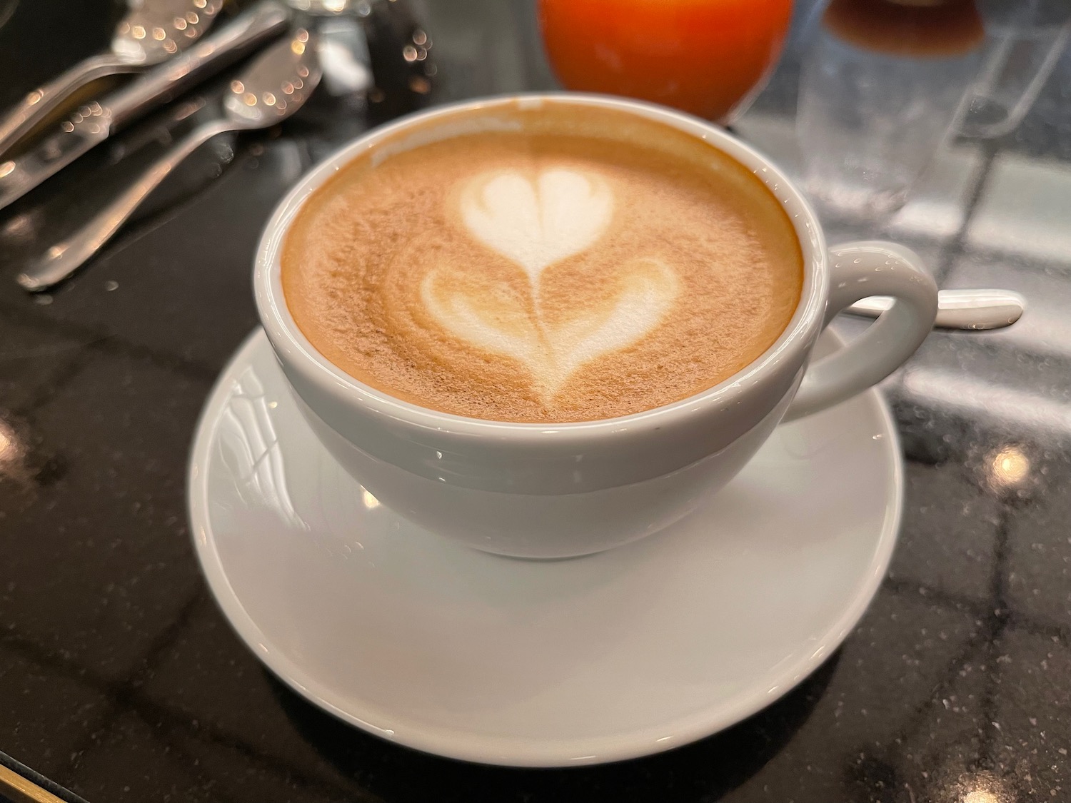 a cup of coffee with a flower design in the foam