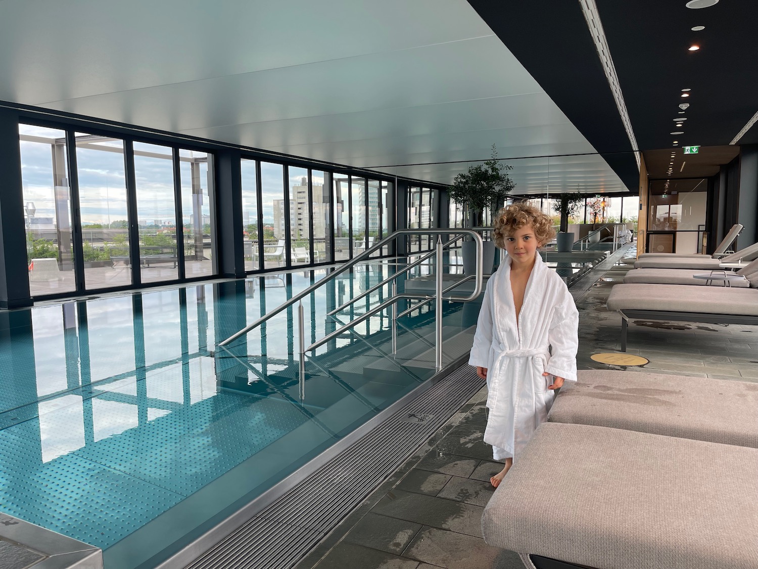 a child in a white robe standing in a pool