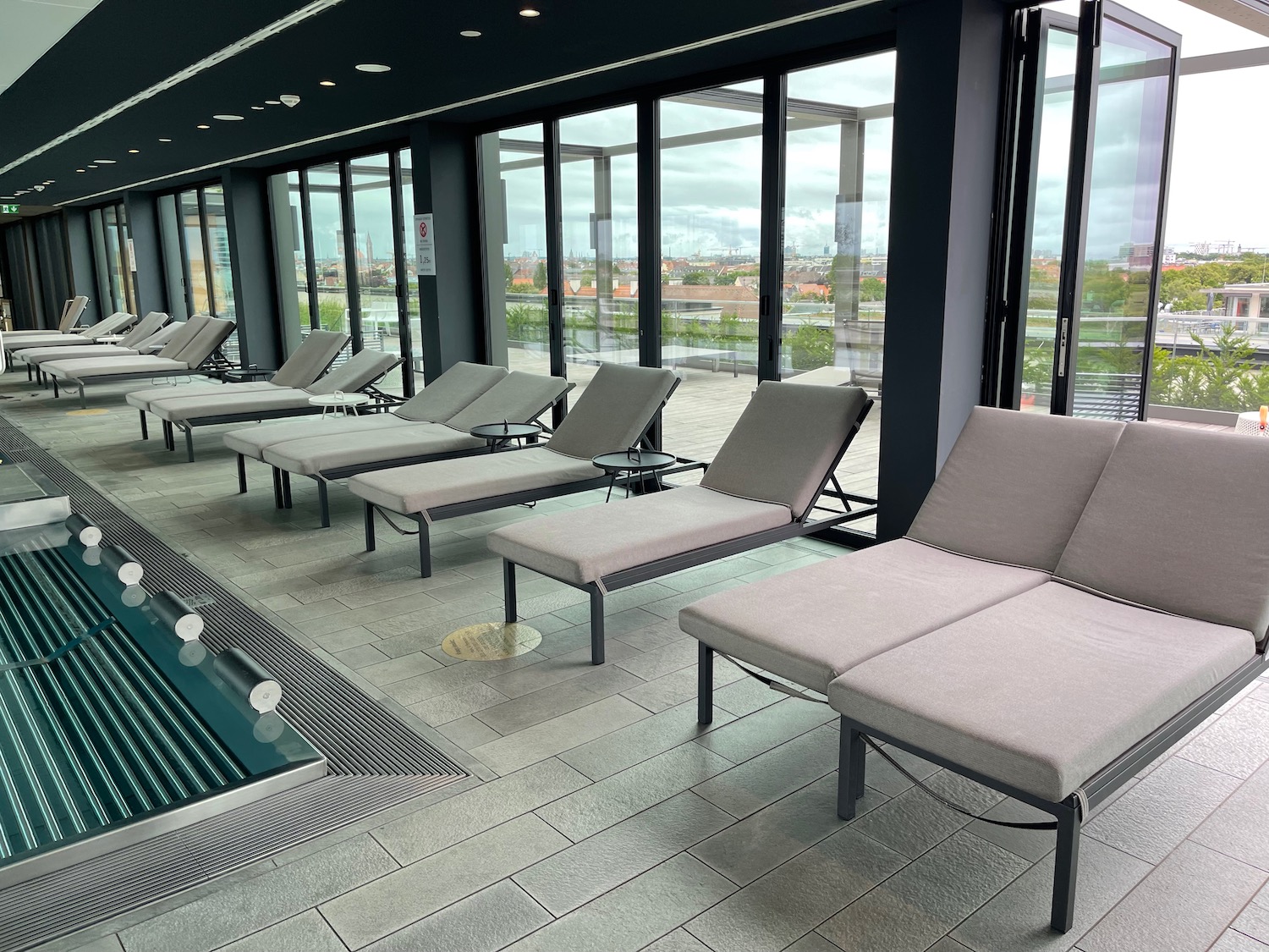 a pool with lounge chairs in a room