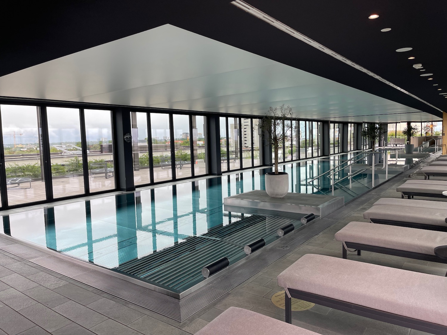 a indoor swimming pool with benches and a large window