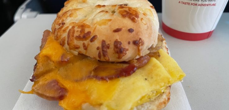 a breakfast sandwich with bacon and cheese
