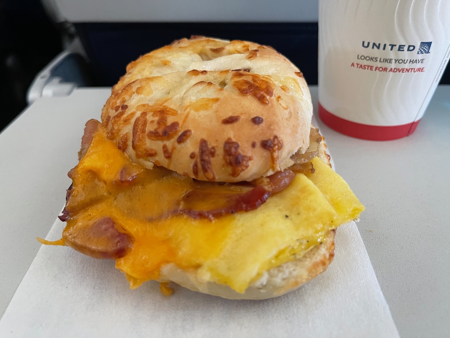 a breakfast sandwich with bacon and cheese