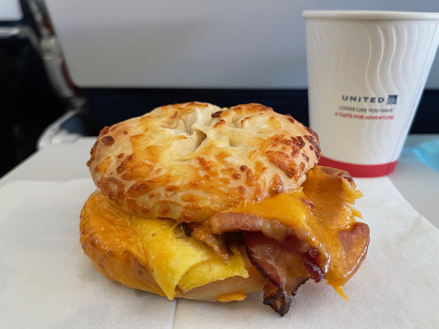 a bagel sandwich with bacon and cheese