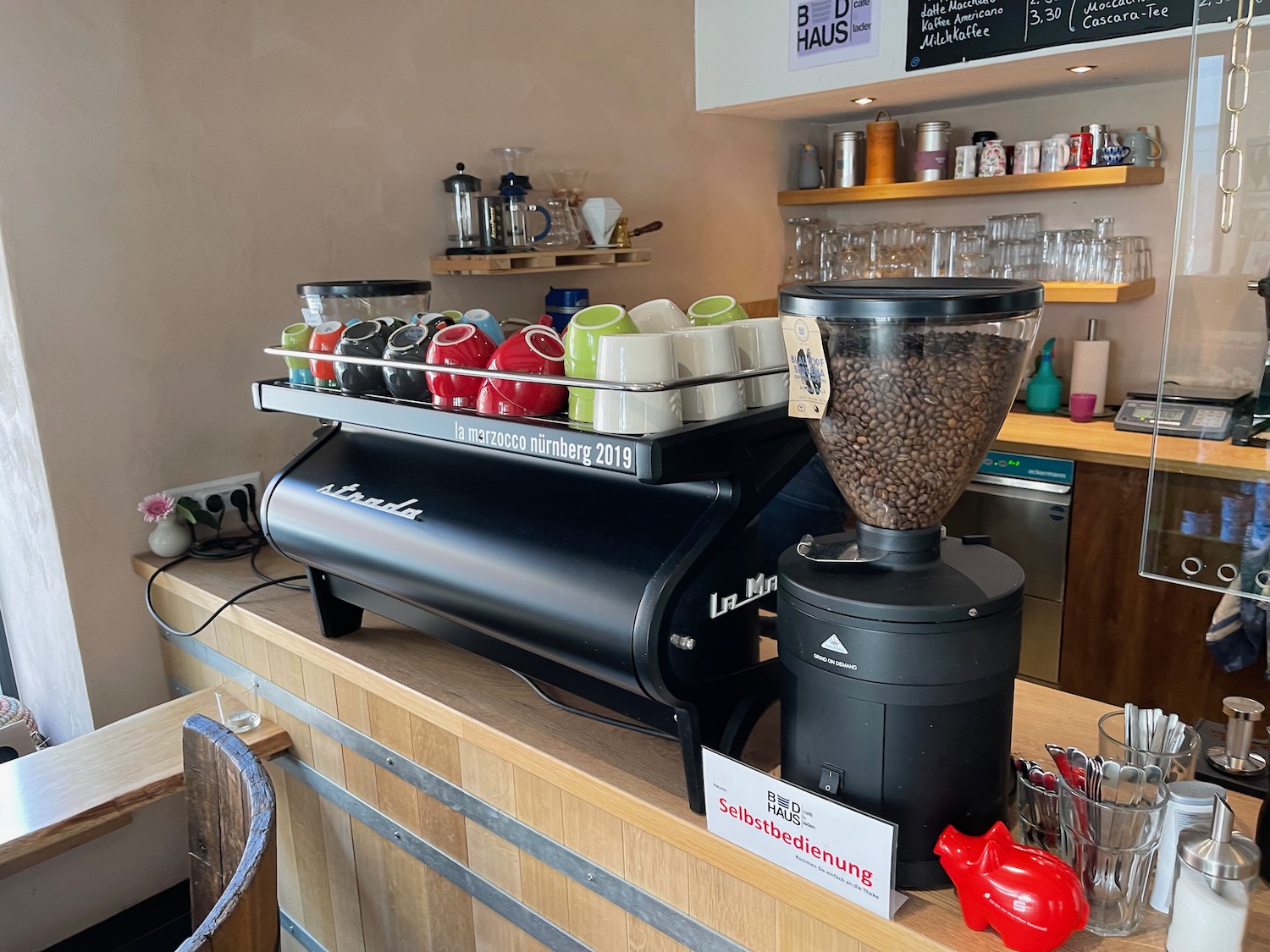 a coffee machine with coffee beans and cups on a counter