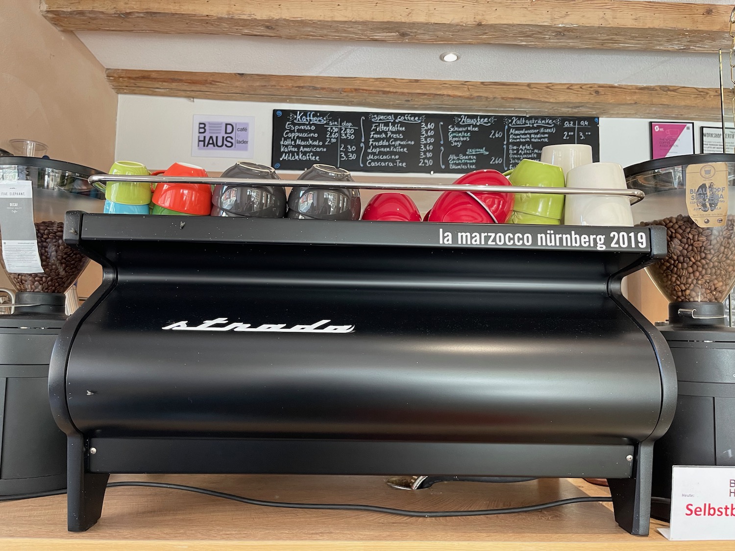 a black coffee machine with colorful cups on top