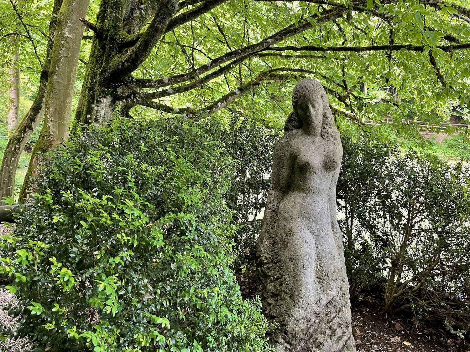a statue of a woman in a forest
