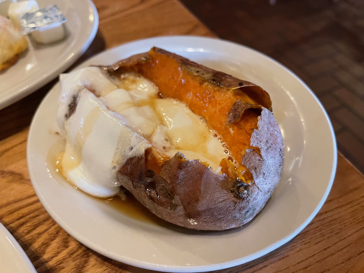 a baked potato with a cream and sauce on a plate