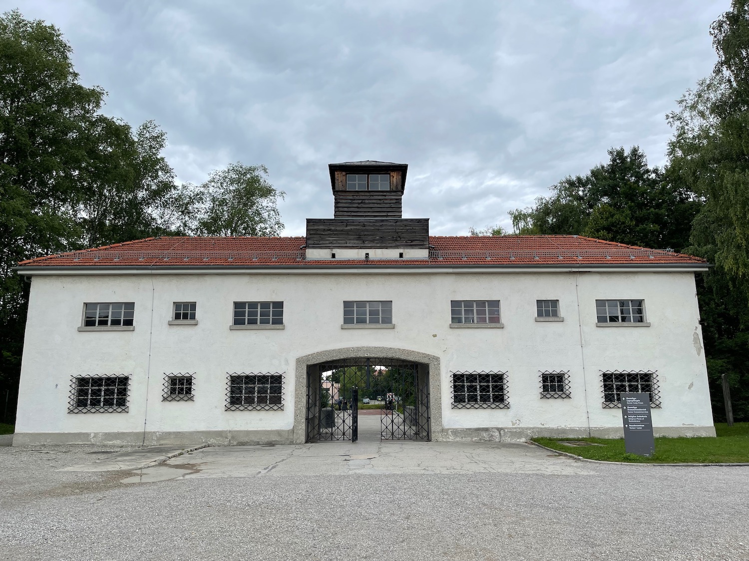 a white building with a red roof and a gate