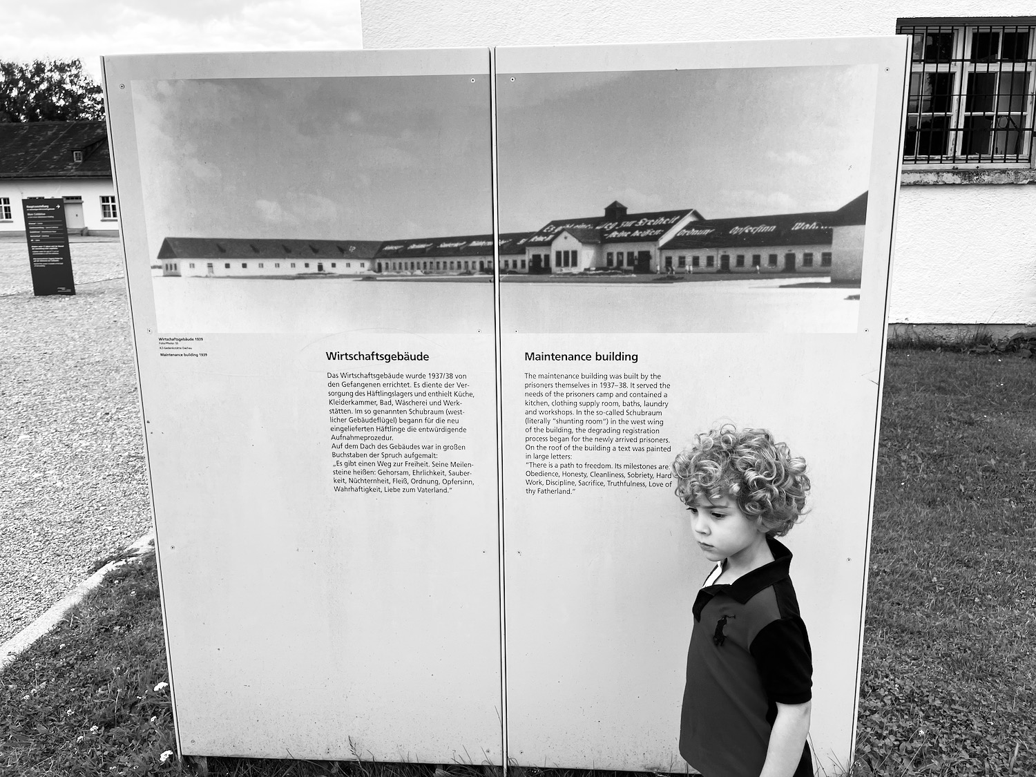 a boy standing in front of a sign
