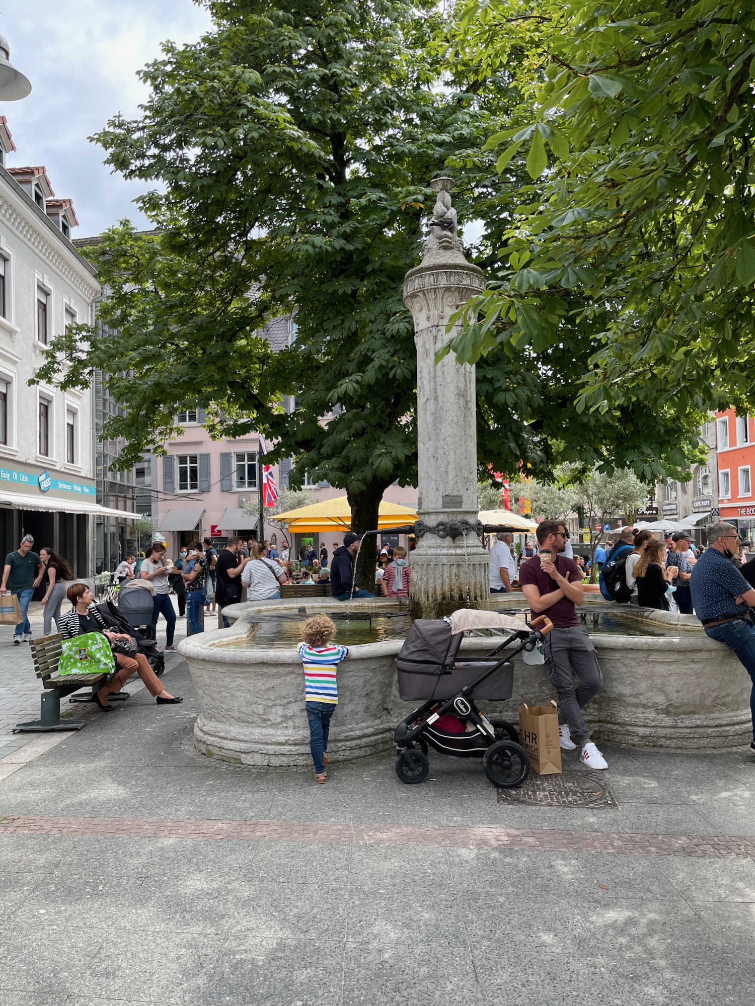 a group of people sitting around a fountain